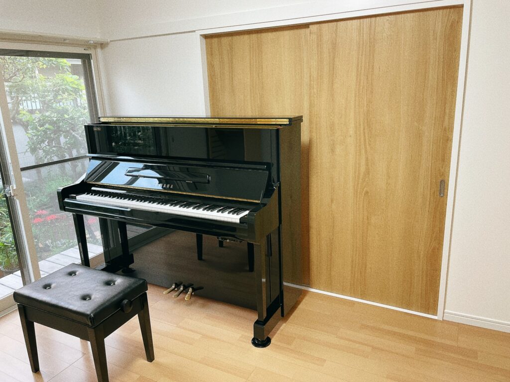 黒いアップライトピアノと北欧風の部屋